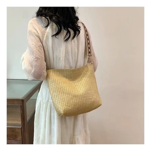 Détail du sac cabas bohème en paille avec une large bandoulière en jacquard vintage