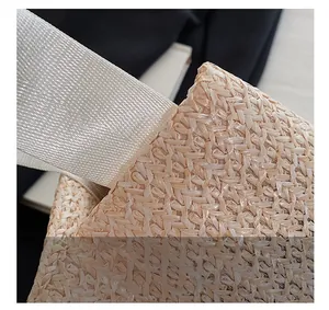 Détail du tissage diagonal et de la sangle en tissu blanc de ce sac à main en paille