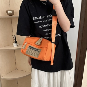 Oranje oxford crossbody sporttas met brede schouderband en stoffen sport-patch