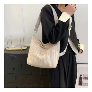 Détail du sac cabas tressé blanc cassé avec une bandoulière jacquard florale violette