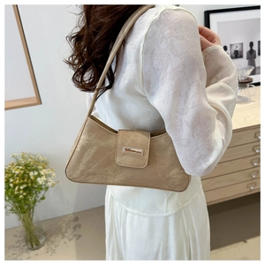 Chic khaki suede baguette bag shown from a side view on model in home setting