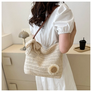 Floral straw tote bag with sunflower decor and lace bow on a female shoulder