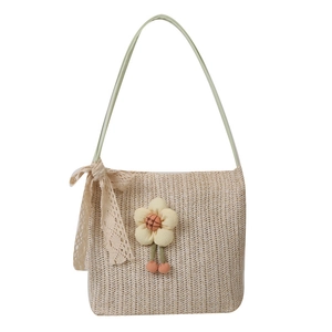 Elegant woven straw tote bag in beige with floral decor and pink pom-pom pendant for summer