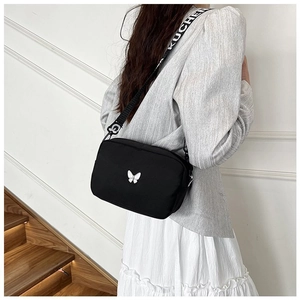 Detail of black nylon crossbody bag with white butterfly and branded jacquard strap