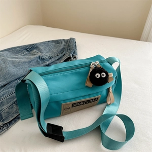 Lake blue nylon oxford cloth crossbody bag with fluffy black pom pom charm