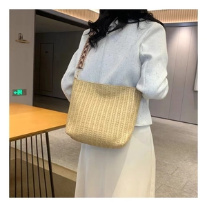 Détail de la bandoulière bohème large avec motifs géométriques sur sac en paille