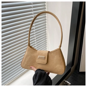 Close-up of light brown matte leather baguette bag with a rectangular metal buckle detail