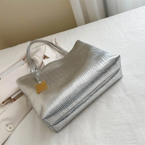 Große silberne Handtasche mit Krokodilmuster, Metallic-Finish und goldenem Anhänger