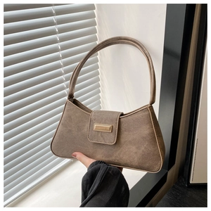 Detail of vintage brown baguette bag featuring matte texture and golden metal buckle
