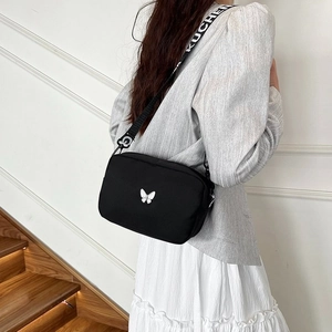 Fashionable black nylon crossbody bag with butterfly logo and woven letter shoulder strap