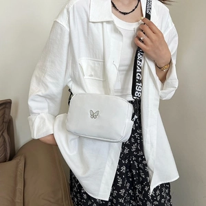 White nylon crossbody bag with silver butterfly charm and branded wide woven strap