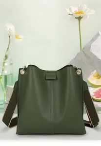 Detail der dunkelgrünen Beuteltasche mit breitem Webriemen und goldener Hardware