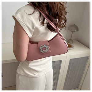 Detail of pink crescent bag with sparkling square rhinestone buckle on leather strap