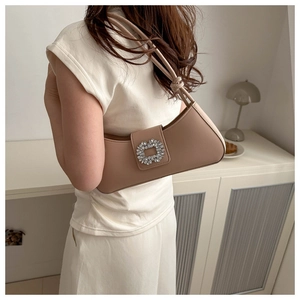 Detail of trendy milk tea beige underarm bag showing diamond-studded crystal buckle