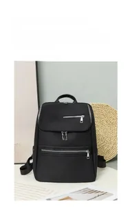 Detail of minimalist black oxford backpack with water-resistant fabric and silver zippers