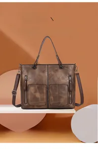 Gros plan d'un cabas vintage marron avec poches zippées à l'avant et poignées robustes
