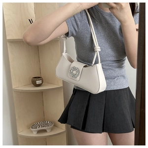 Detail view of white leather underarm bag with sparkling square rhinestone buckle