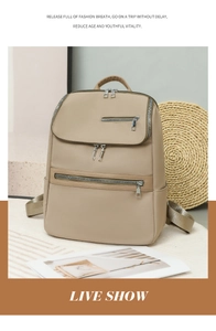 Detail of khaki oxford cloth backpack with multi-zipper compartments and adjustable straps