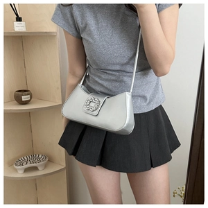 Detail of silver metallic underarm bag with sparkling rhinestone square buckle and strap