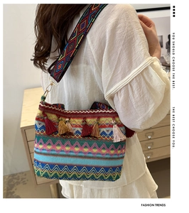 Macro detail of bohemian bucket bag featuring colorful tassels and woven geometric patterns