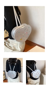 Close-up of silver heart-shaped backpack with colorful gems and star studs