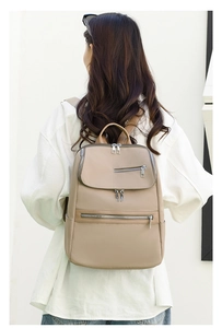 Detailed side view of khaki Oxford cloth backpack showing side pocket and zipper layers