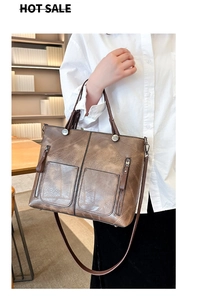 Détails de la texture du cuir marron et poches à fermeture éclair sur le grand sac cabas