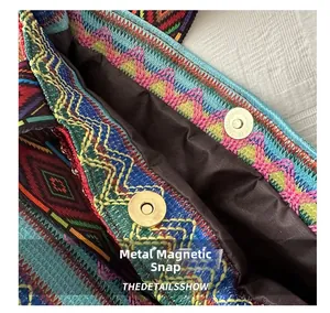 Macro view showing the metal magnetic snap closure and embroidery on the straw bucket bag