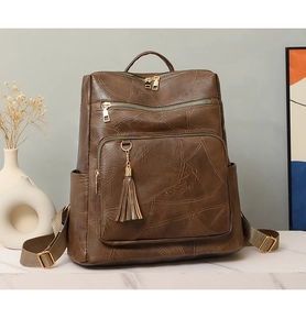 Close-up of vintage brown PU leather backpack with tassel detail and geometric stitching