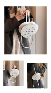 Detail of white heart-shaped backpack featuring colorful gemstones and star ornaments