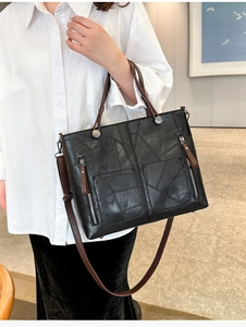 Détails du sac cabas noir avec texture patchwork, doubles poches et bandoulière marron