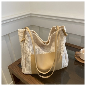 Detailed view of cream woven tote bag with leather pocket and magnetic clasp closure