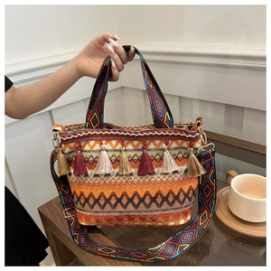 Close-up of bohemian woven bucket bag featuring colorful tassels and geometric patterns
