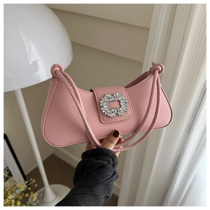 Detail of pink baguette bag showing crystal buckle and knotted strap on matte leather