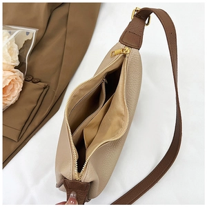Close-up of beige and brown hobo bag showing zipper closure and fabric lining