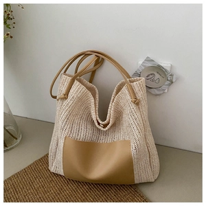 Detail of hand-woven straw tote bag with beige leather pocket and slim shoulder straps