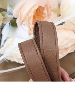Detail of a brown lychee pattern leather shoulder strap with neat stitching and smooth edges