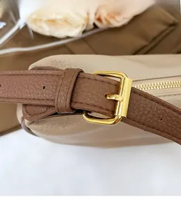 Detail of premium brown lychee texture leather strap with polished gold buckle and zipper