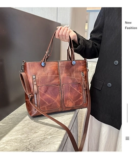 Détail du sac cabas en cuir marron avec fermetures éclair et bandoulière réglable pratique