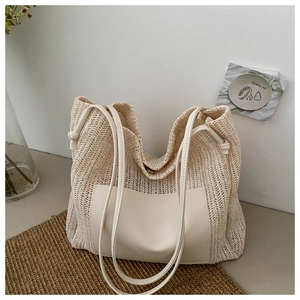 Close-up of beige woven tote bag with smooth faux leather patch and magnetic closure