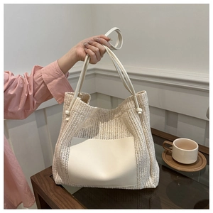 Detailed close-up of straw woven tote bag with cream PU leather pocket and fine stitching