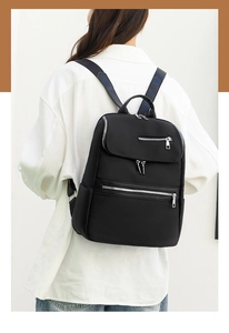Detail view of large capacity black oxford backpack with multiple zipper pockets