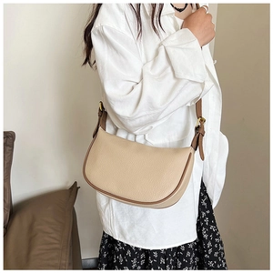 Detail of beige crescent hobo bag with lychee texture leather and gold hardware