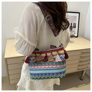 Close-up of bohemian woven crossbody bag with colorful tassels and geometric patterns