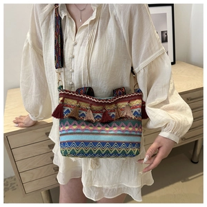 Detail of colorful ethnic woven bucket bag with tassels and patterned shoulder strap