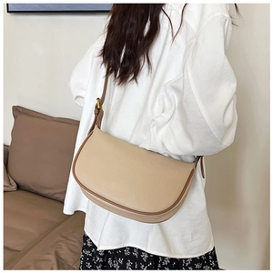 Detailed view of beige lychee texture leather on a stylish minimalist crescent shoulder bag