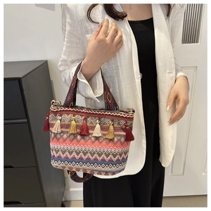 Detail of colorful woven bohemian bucket bag with vibrant fringe and geometric patterns