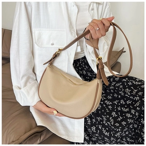 Close-up of beige lychee grain leather hobo bag with adjustable brown strap