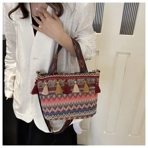 Close-up of bohemian bucket bag with colorful geometric patterns and decorative fringe