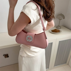 Pink underarm baguette bag with sparkling diamond buckle shown on a female model